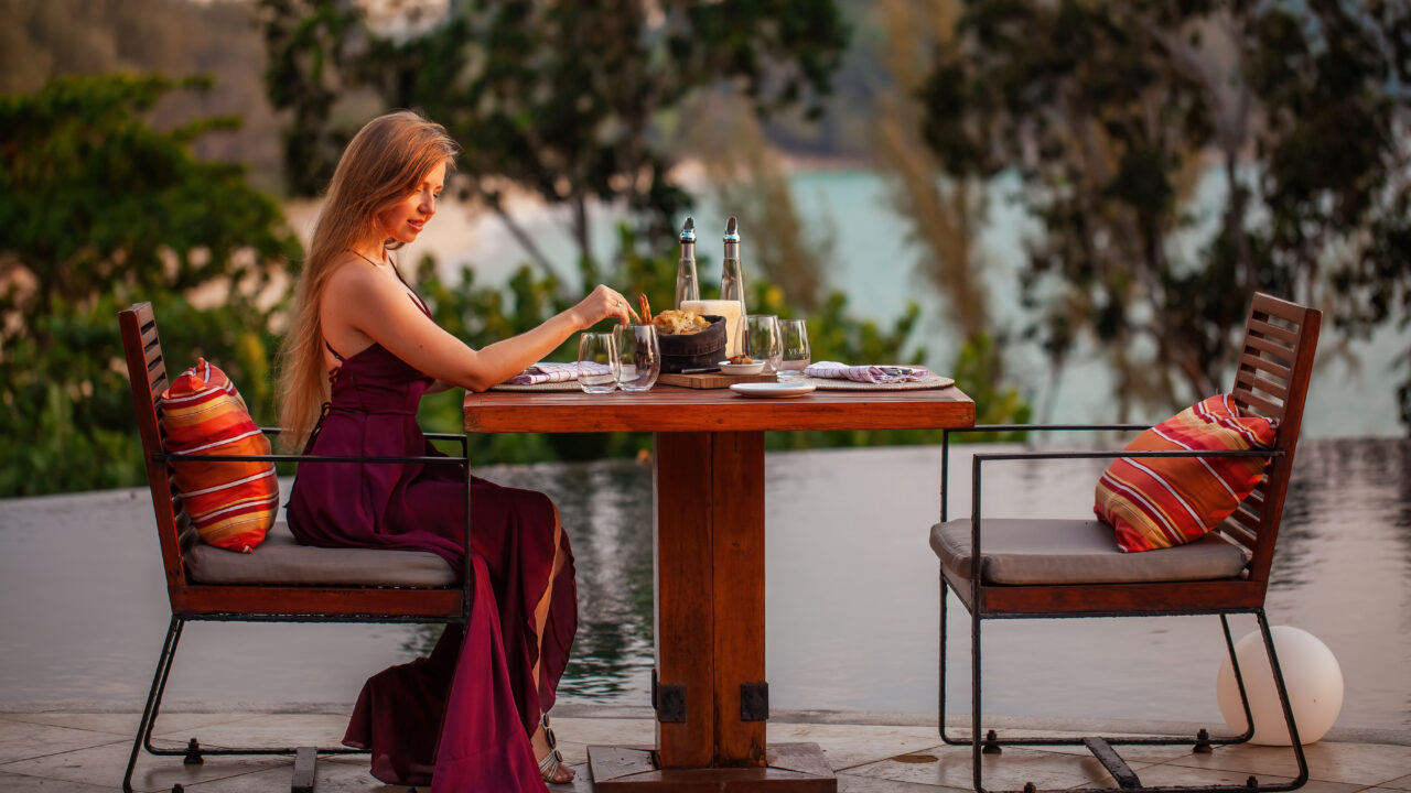 Happy woman having dinner alone outside.