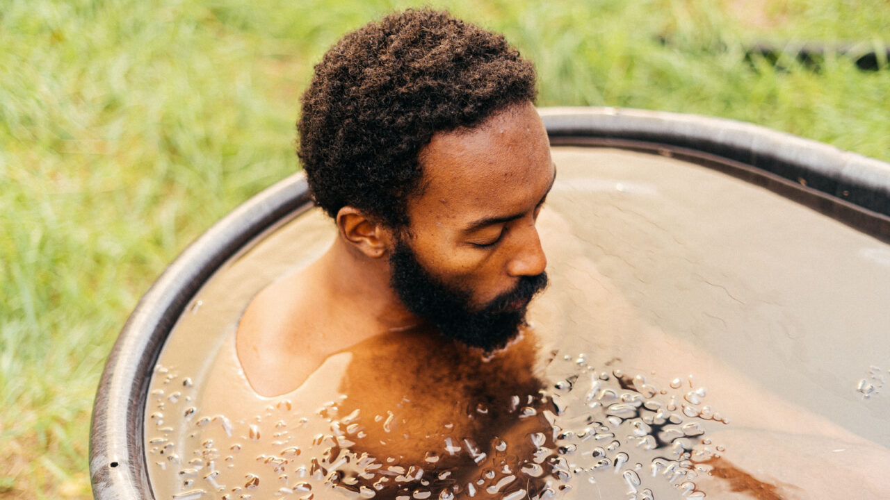 Calm man sitting in ice bath.