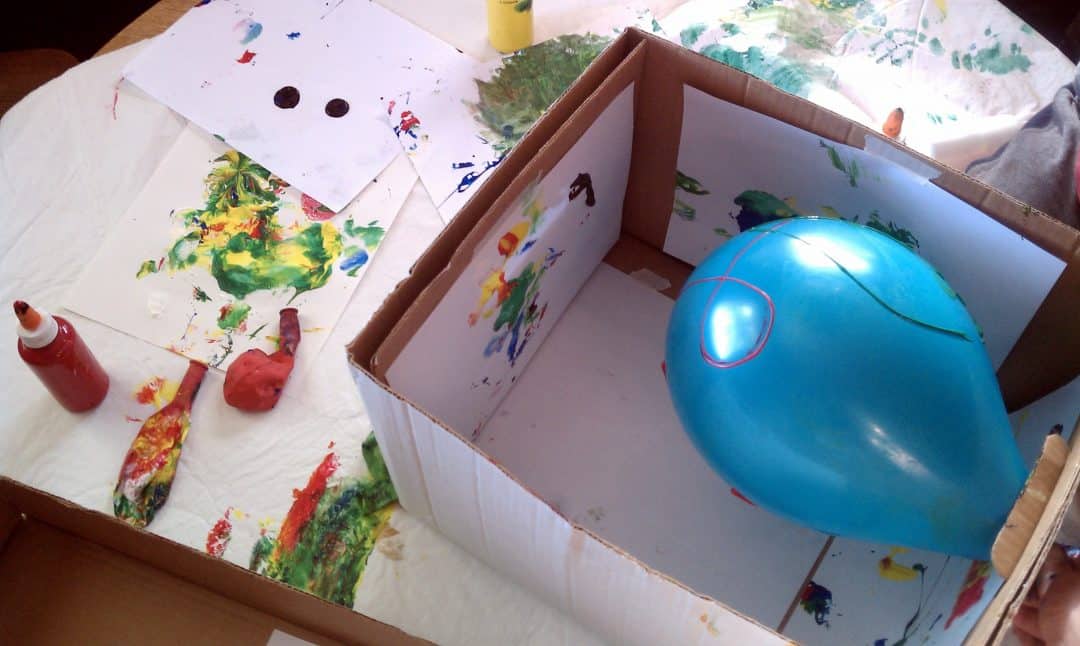 Balloon in a box with paint on it.